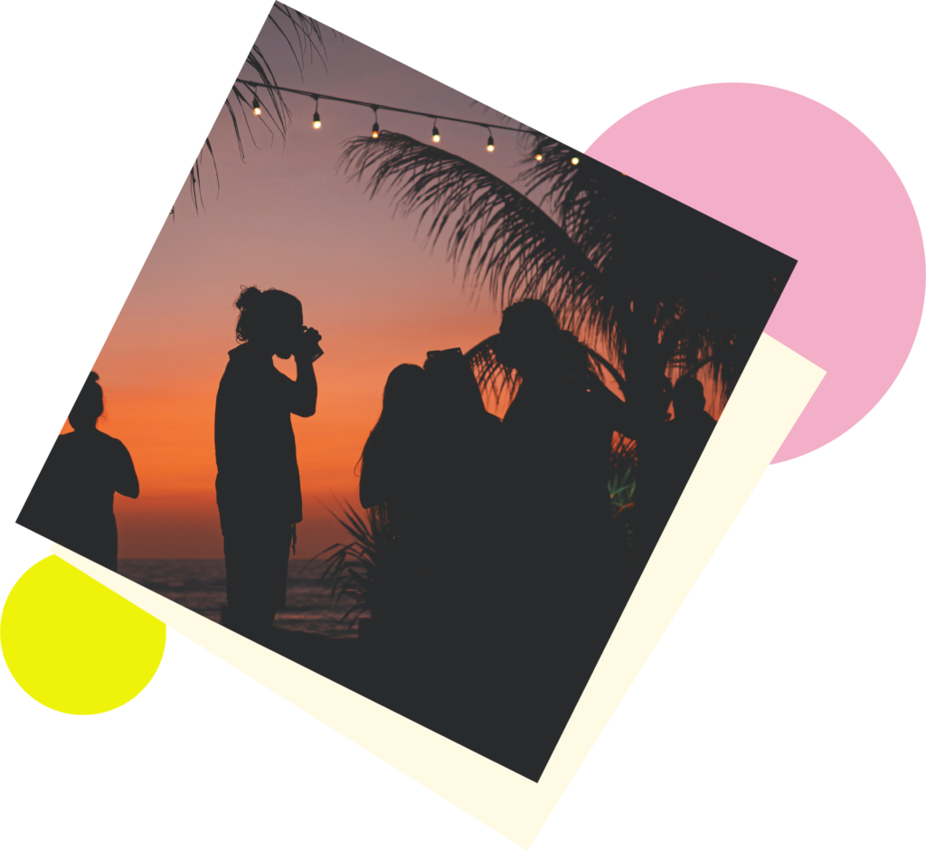 A photograph of a sunset scene with people drinking from LumiCups on the beach.